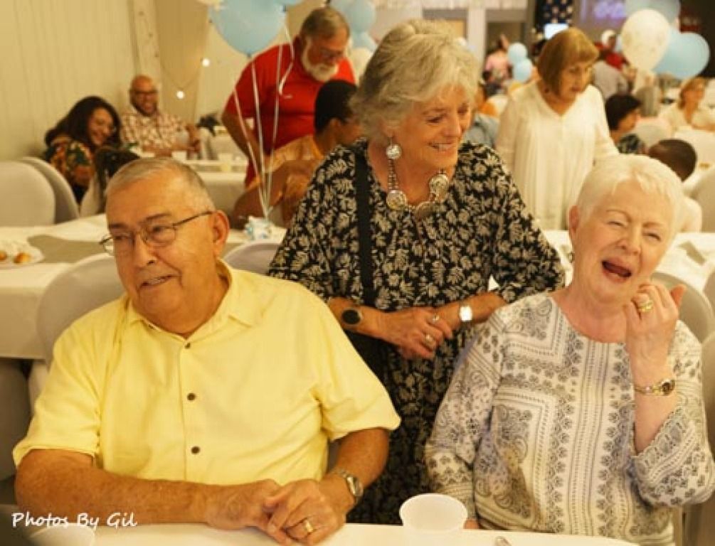 Elderly friends share a joyful moment at a gathering.