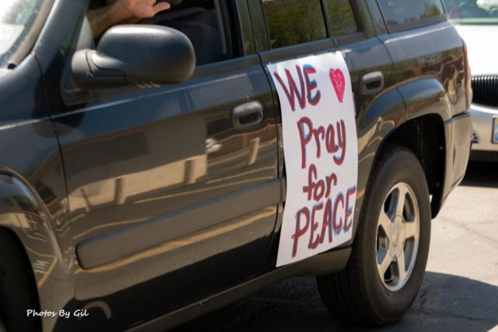 A dark SUV with a large, handmade sign on the side.