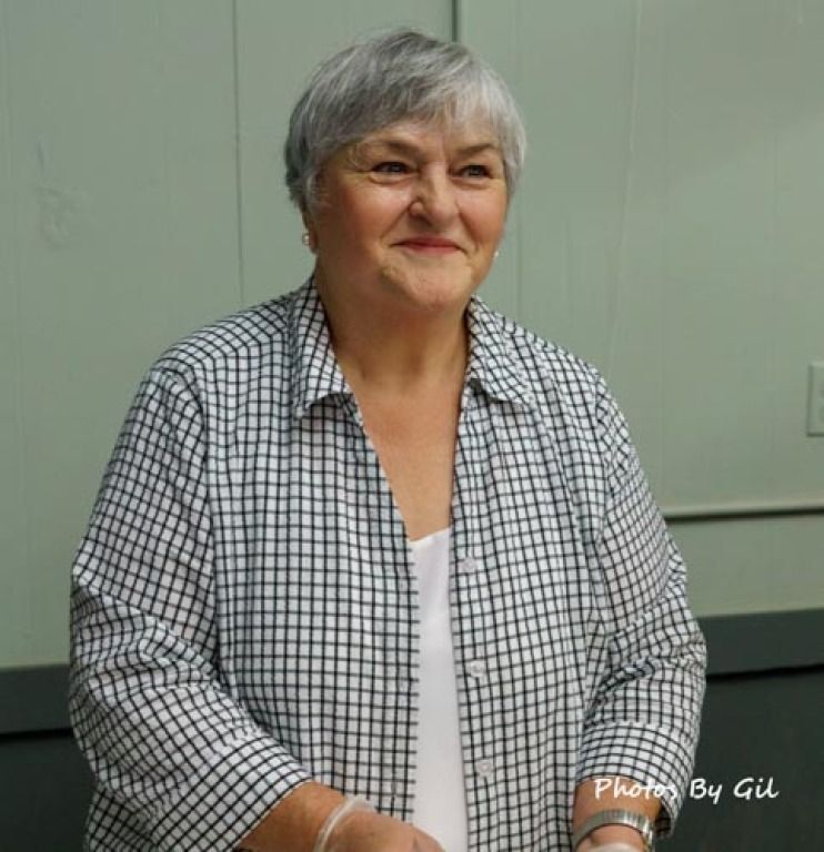 An elderly woman with short gray hair smiles warmly.