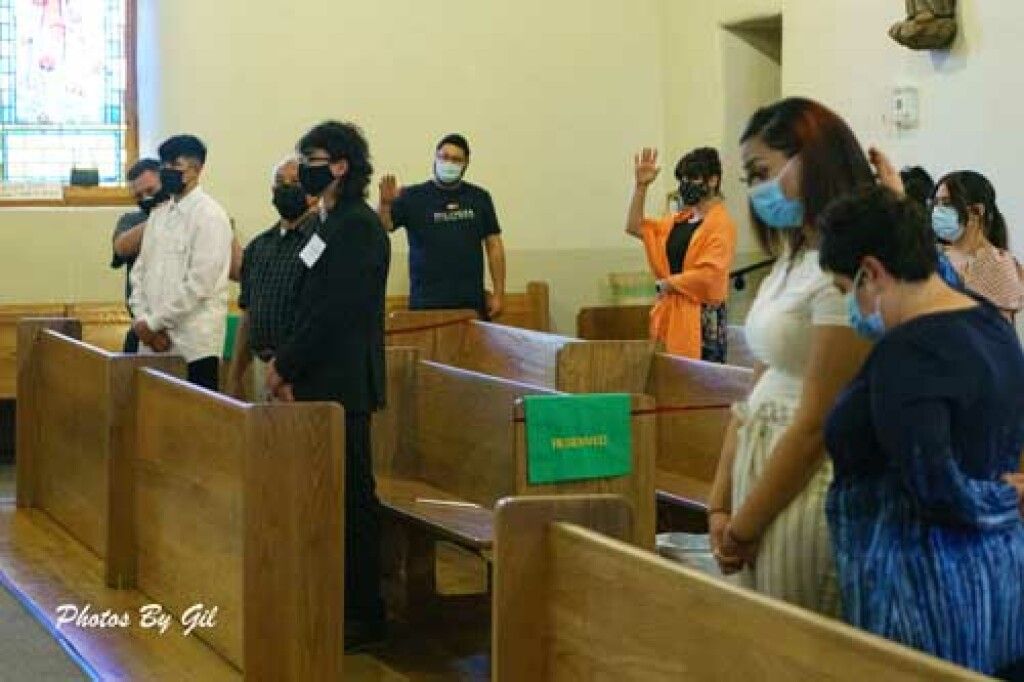Congregants wearing masks engage in prayer inside a church. 