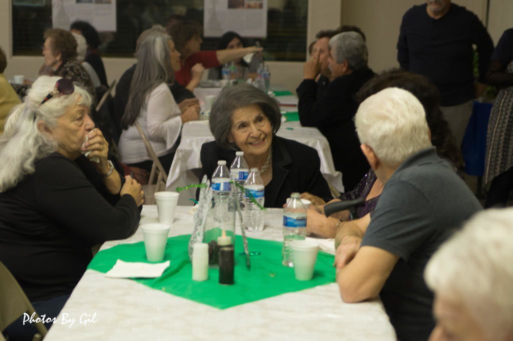 Elderly woman smiling at a community event.