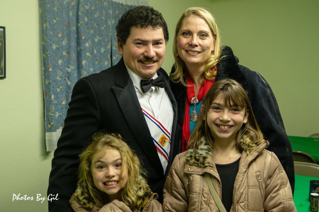 A family of four smiling warmly.
