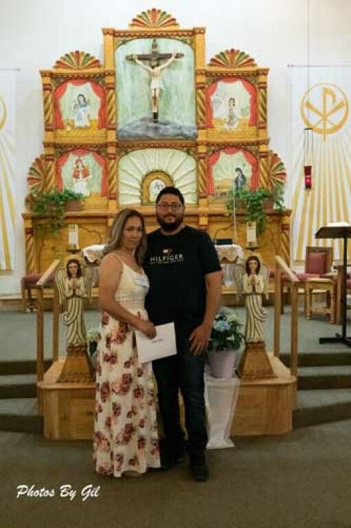 A couple stands in a church, smiling softly.