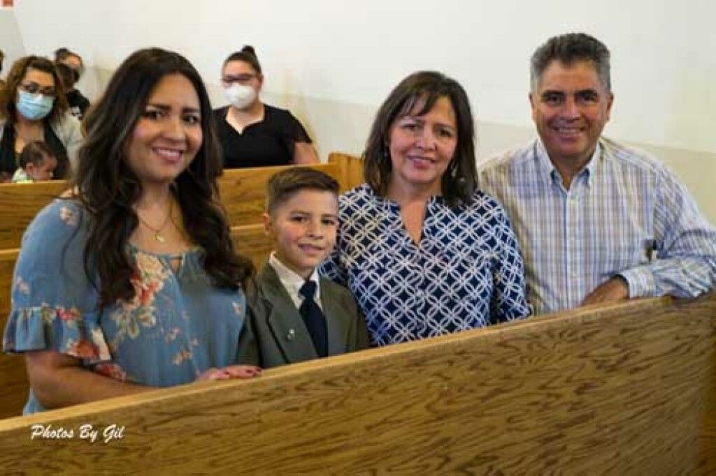 A smiling family of four poses inside a church.