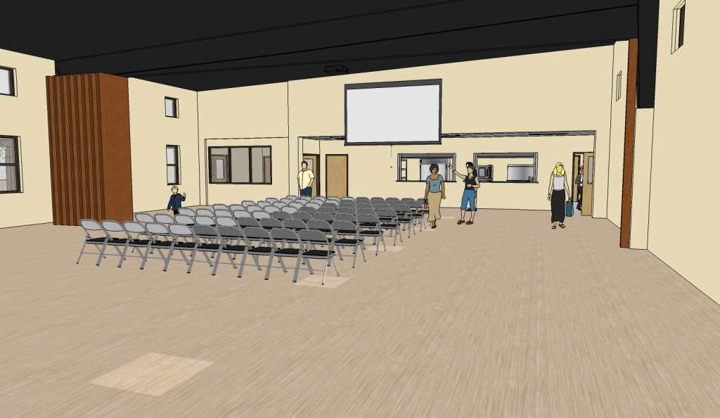 A spacious room with rows of empty gray chairs facing a large screen. 