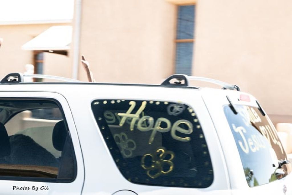 A white SUV with Hope written in yellow paint on its window.