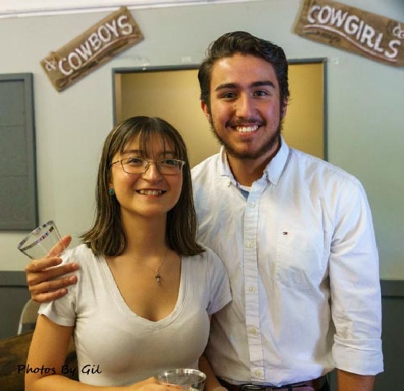 A smiling woman and man pose together at a casual event.