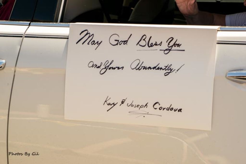 A white car door displays a handwritten sign.