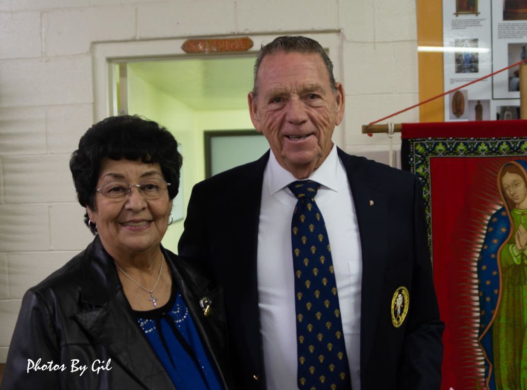 An elderly couple smiles warmly at the camera.