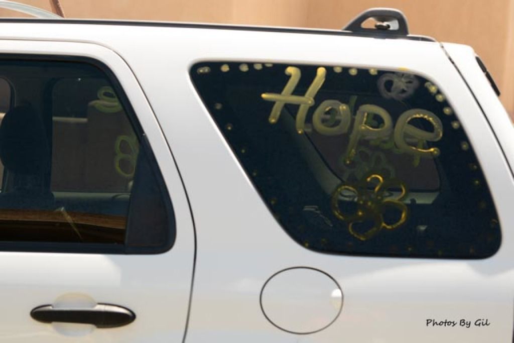 A white vehicle with Hope written in large, yellow letters on the rear window.