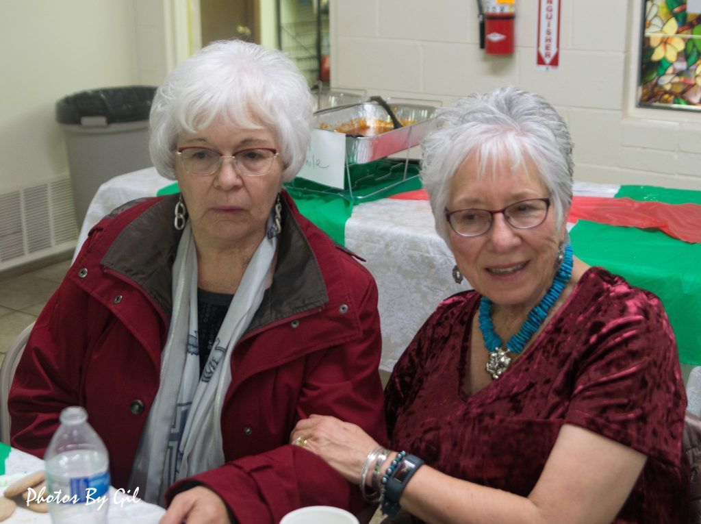 Two older women sitting together at a table.