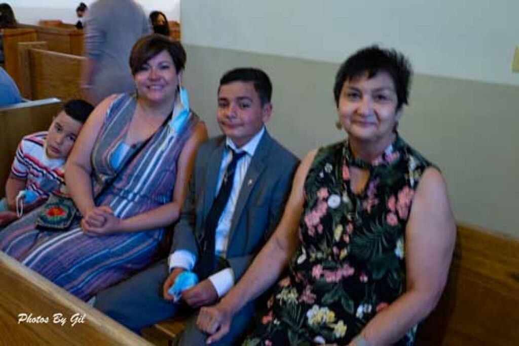 The adults are smiling, and a young boy in a suit appears content.