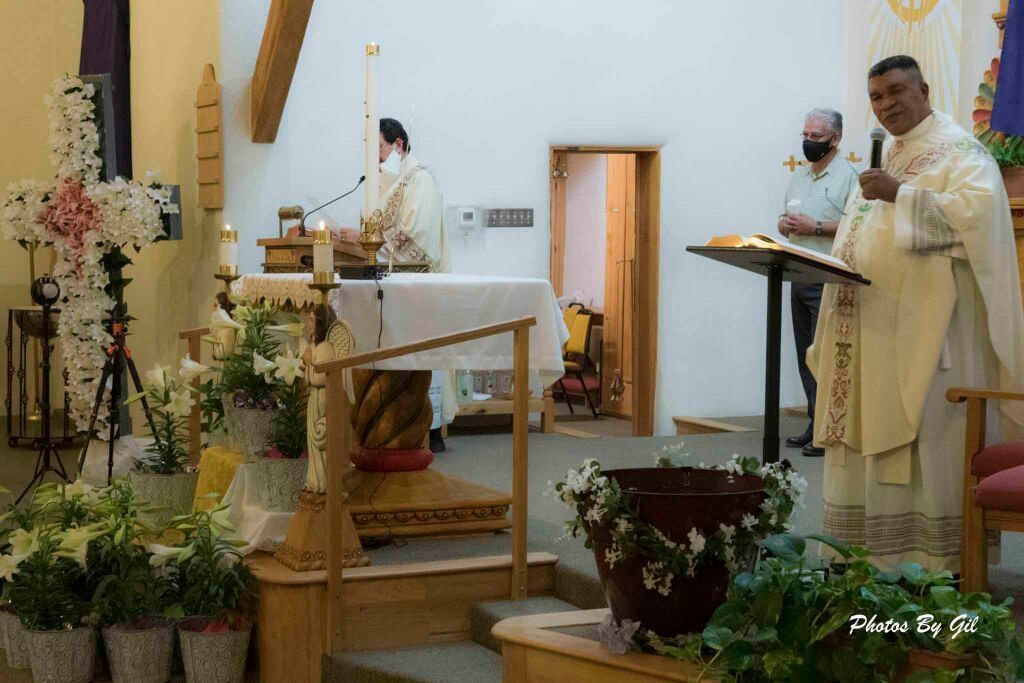 An altar scene in a church with two priests in white robes.