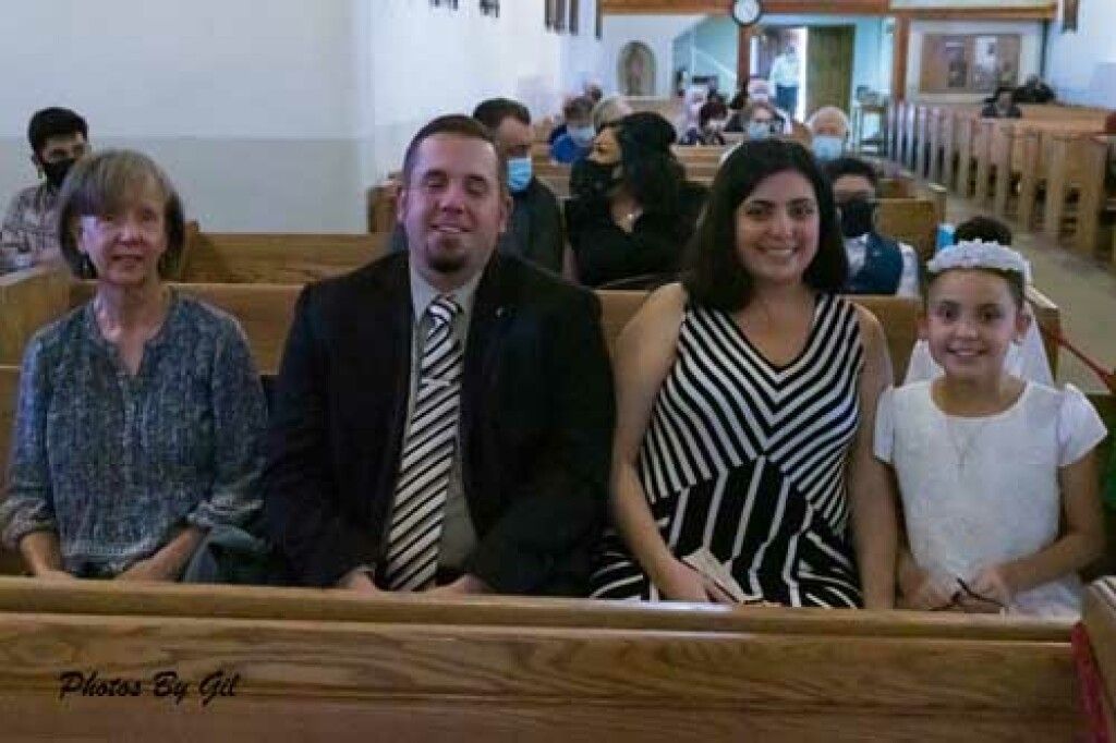 A happy family seated in a church pew.