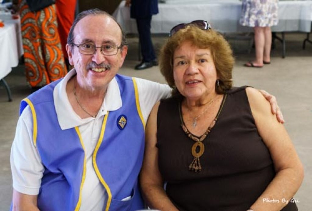 A smiling man and woman pose closely together indoors. 