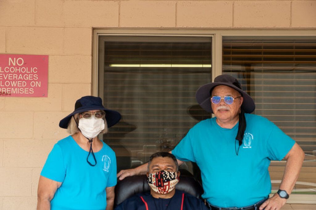 Three people are outside a building.