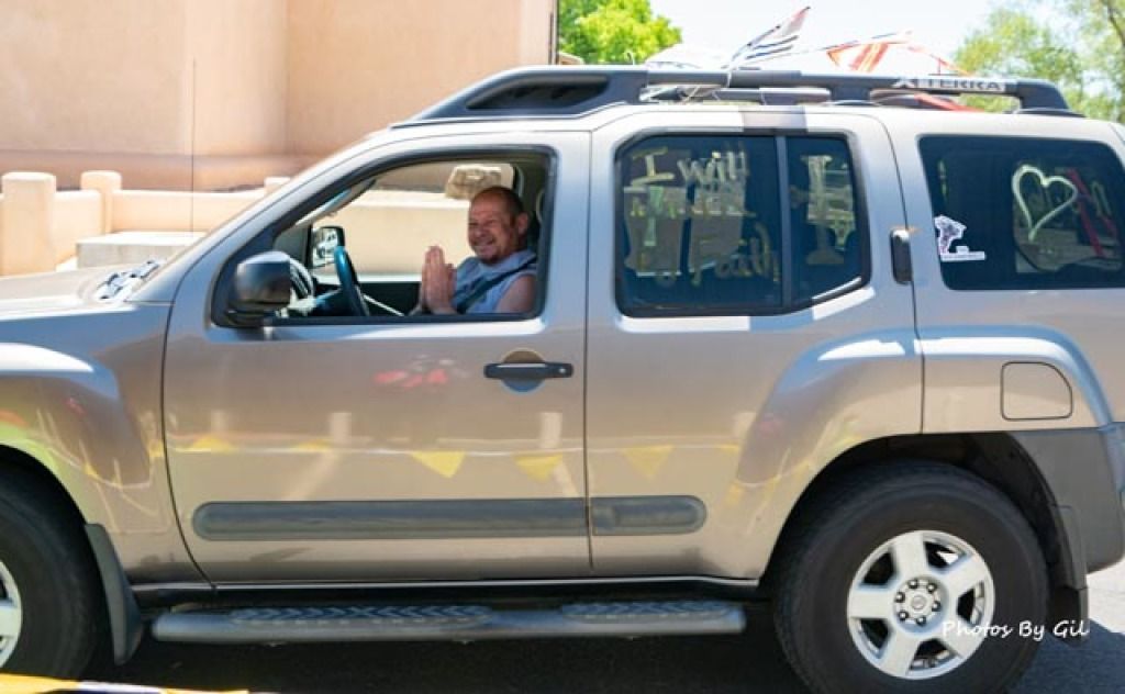 A smiling man sits inside a gray SUV.