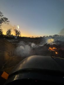 A car is driving down a road with smoke coming out of the windshield.