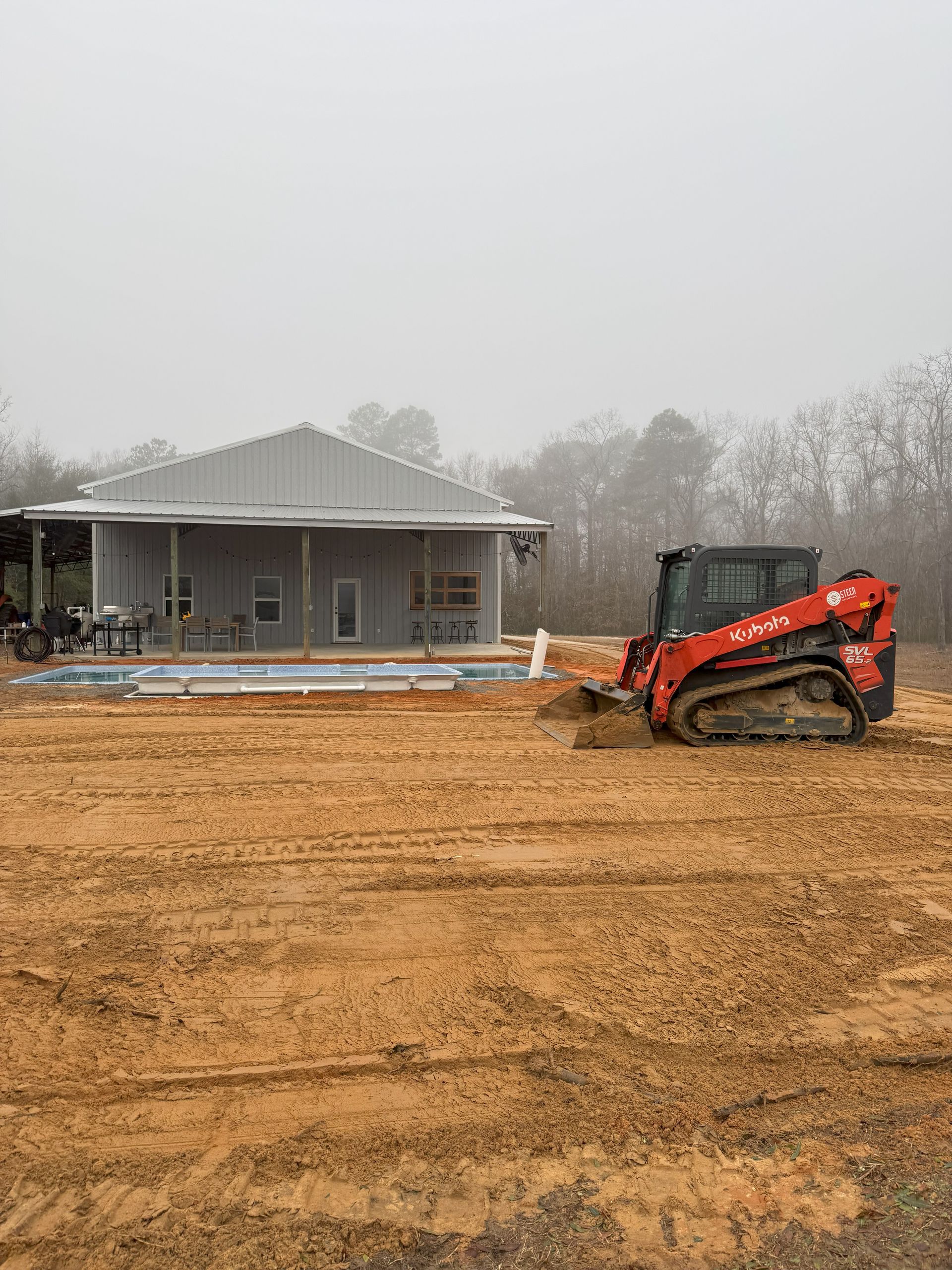 A bulldozer is moving dirt in front of a house.