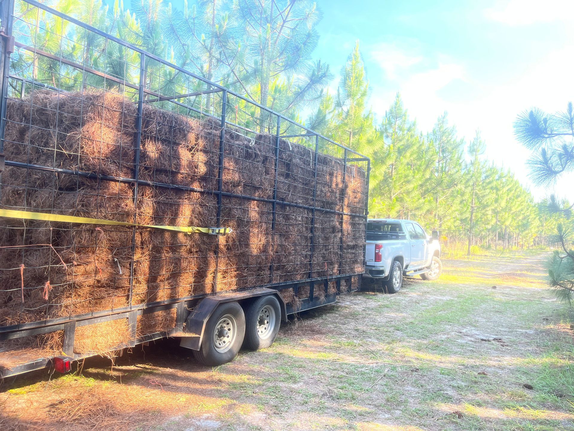 A truck is pulling a trailer full of hay.