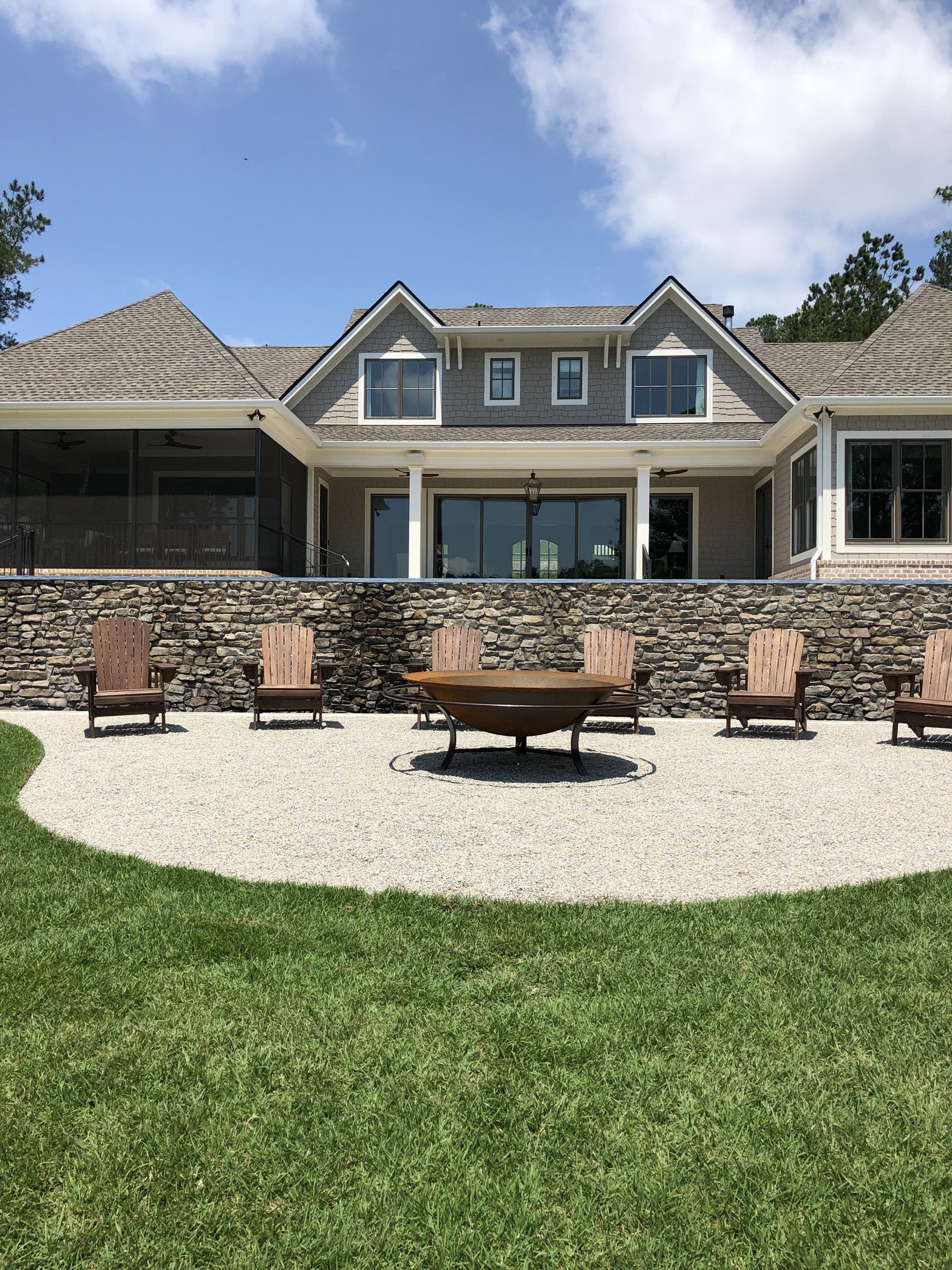 A large house with a fire pit in front of it.