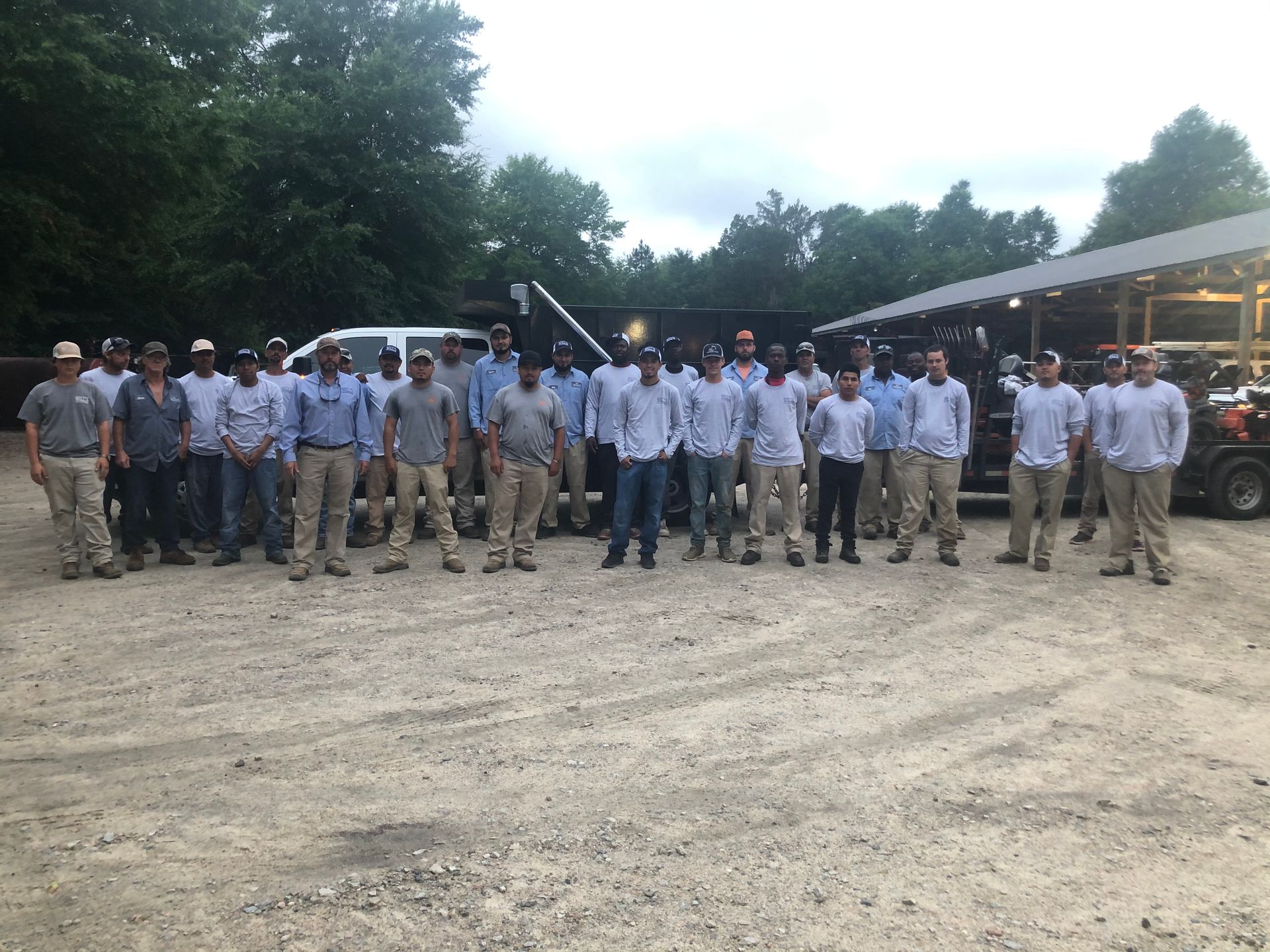 A group of men are posing for a picture in a parking lot