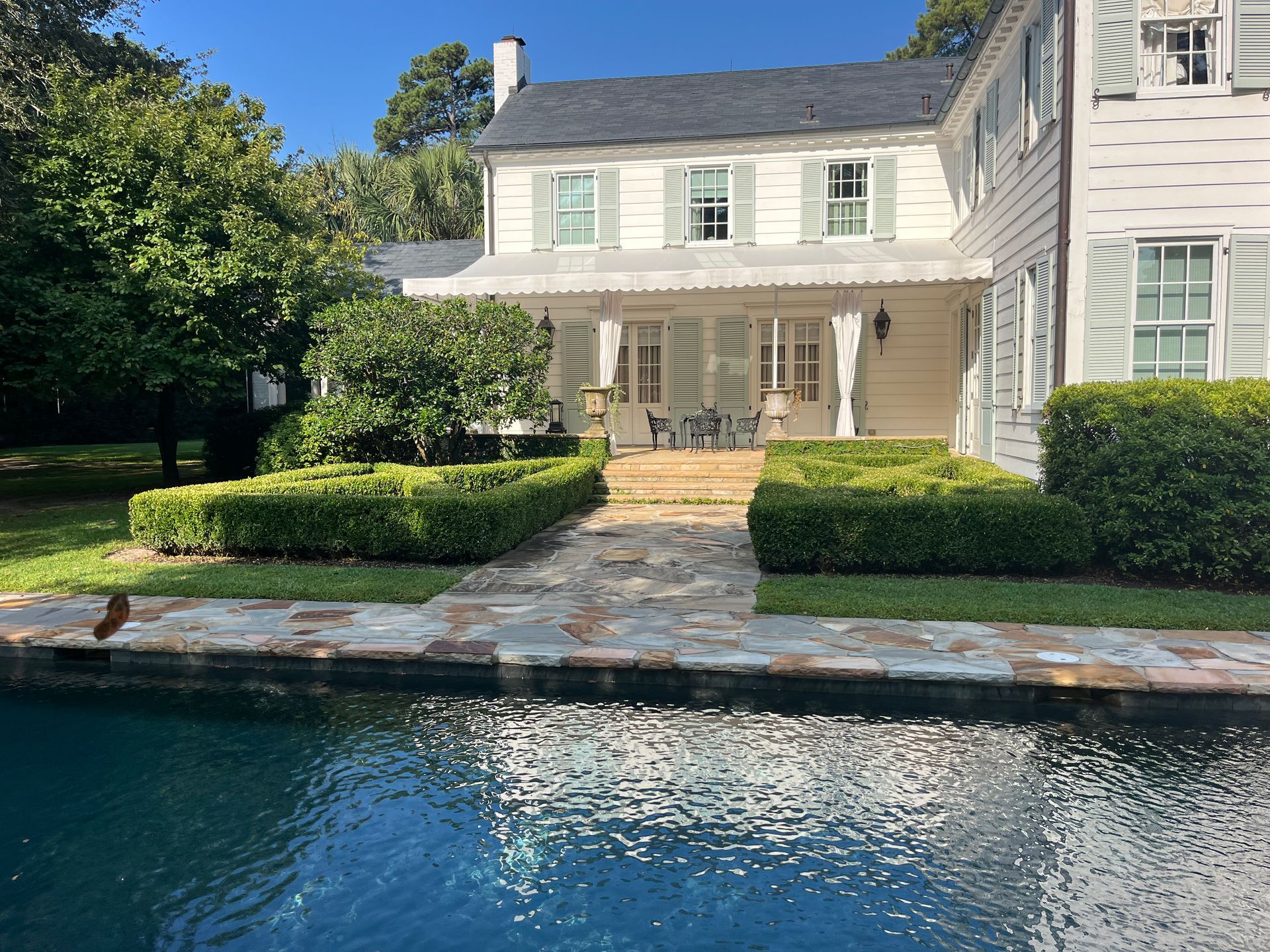 A large white house with a swimming pool in front of it