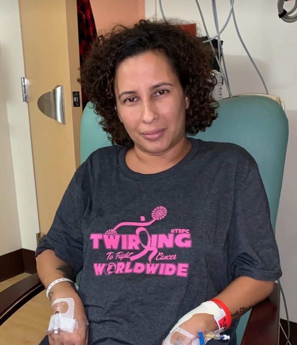 A woman is wearing a shirt that says twirling worldwide