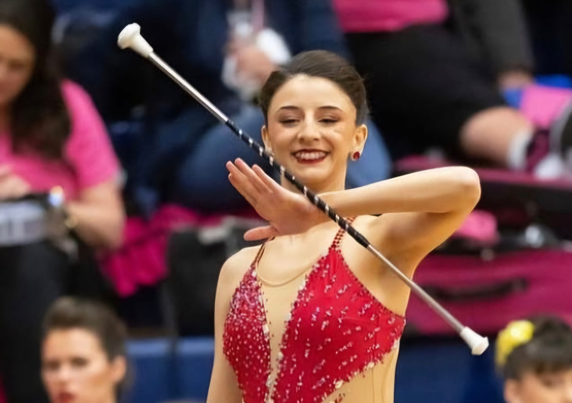 A woman in a red dress is holding a baton