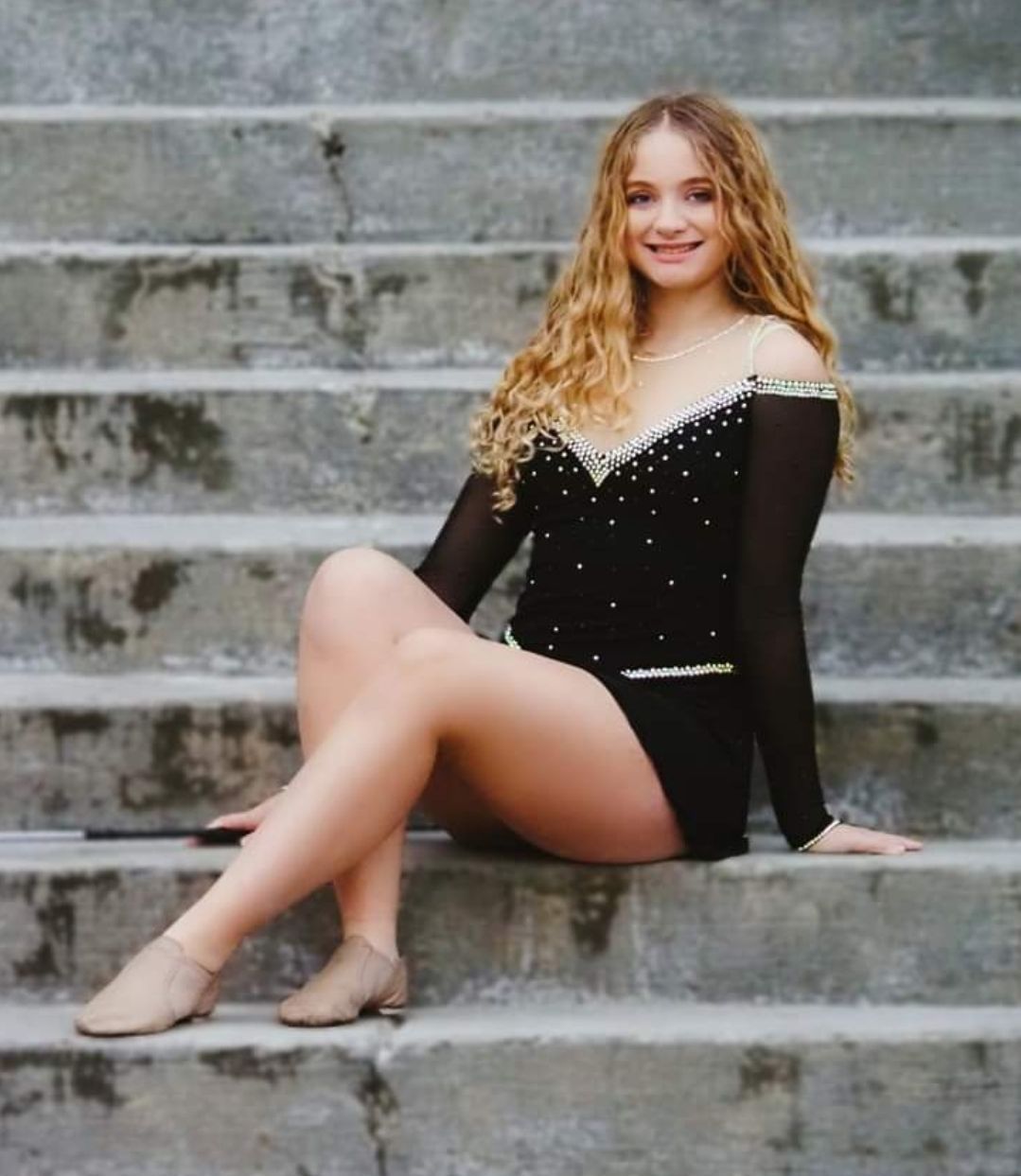 A girl is standing in front of a sign that says madi 's mission seats.