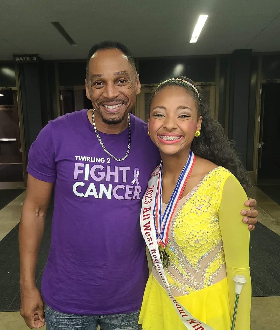 A man is wearing a purple shirt that says fight cancer