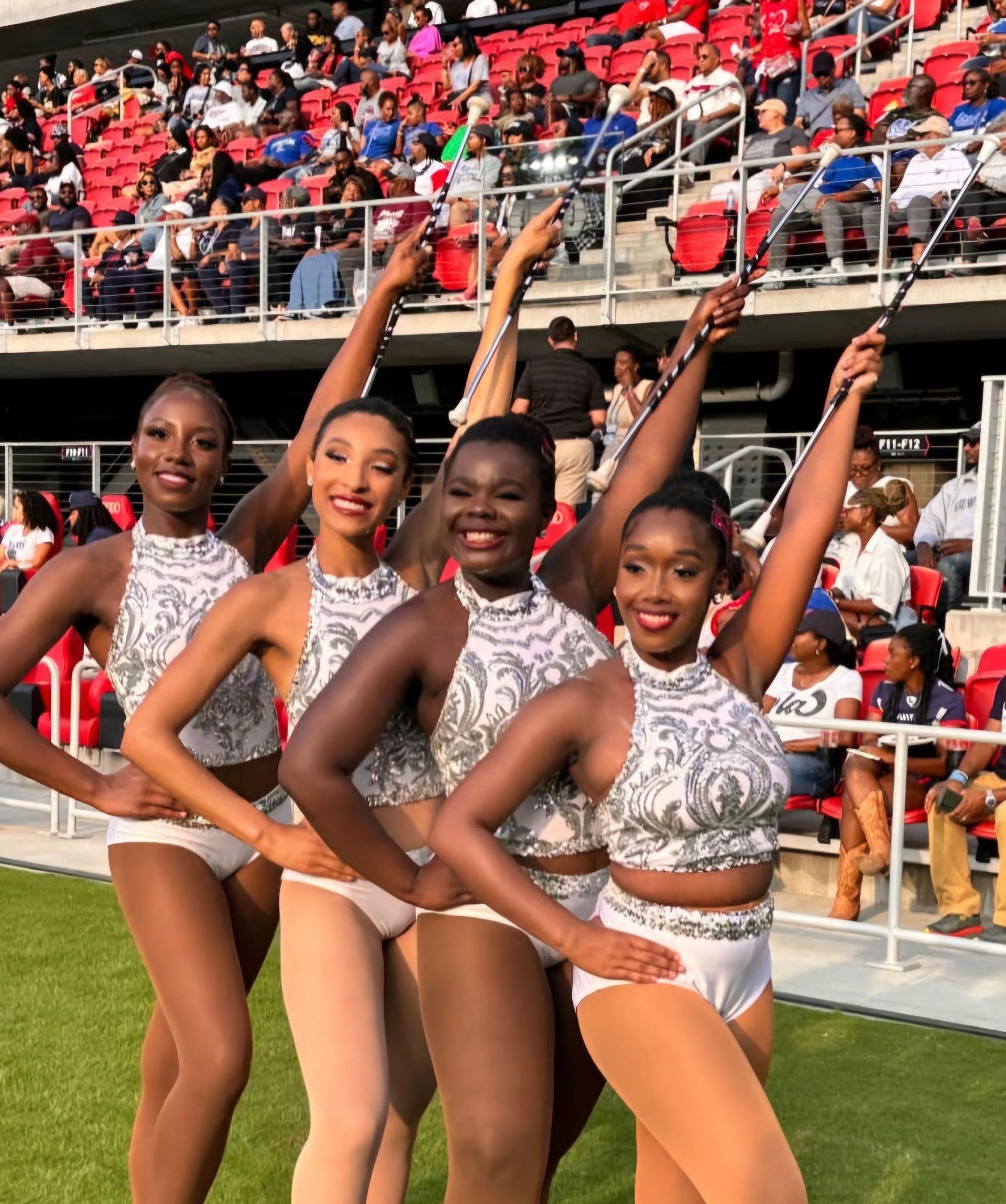 A group of cheerleaders are posing for a picture with their arms in the air