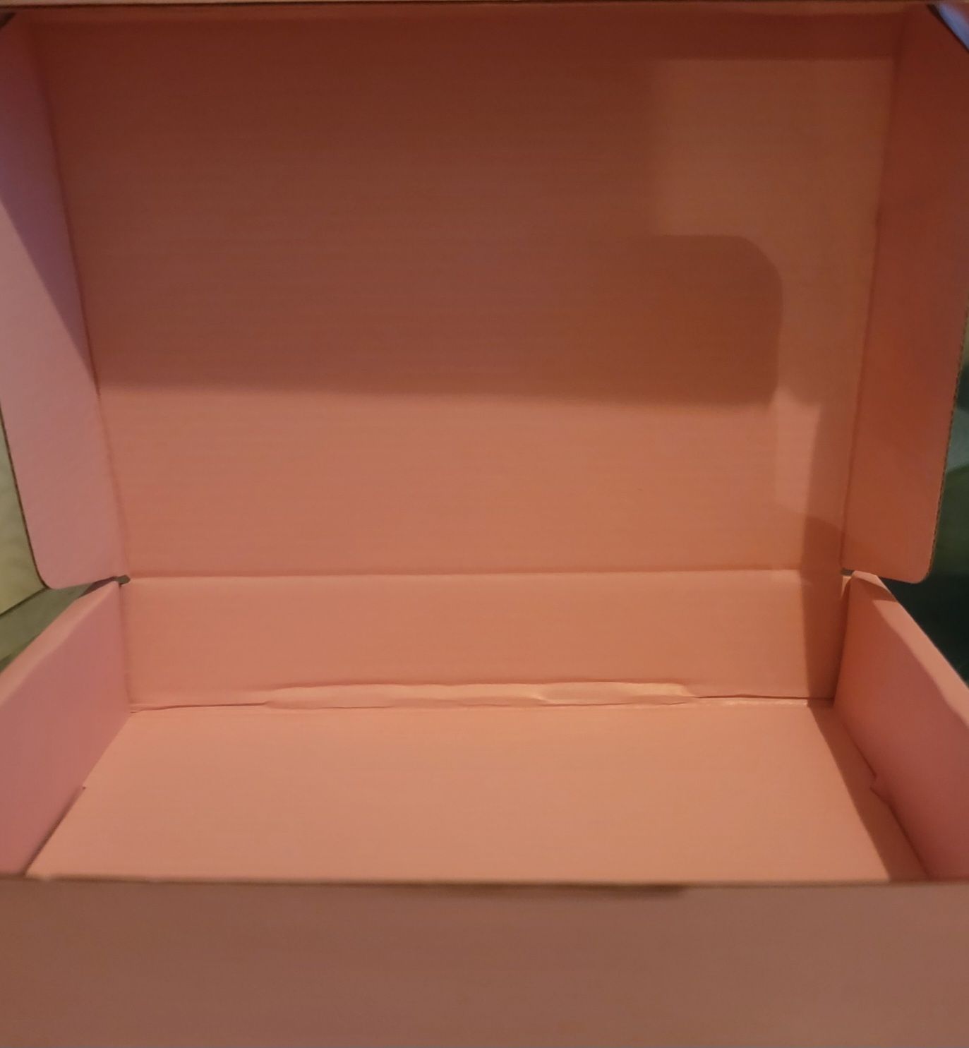 Pink, open cardboard box with a pale pink interior.