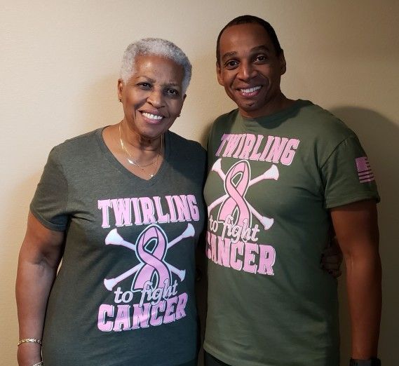 A man and a woman wearing shirts that say twirling to fight cancer