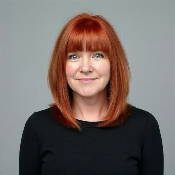 A man is holding a dog in his arms and the dog is wearing a sweater.