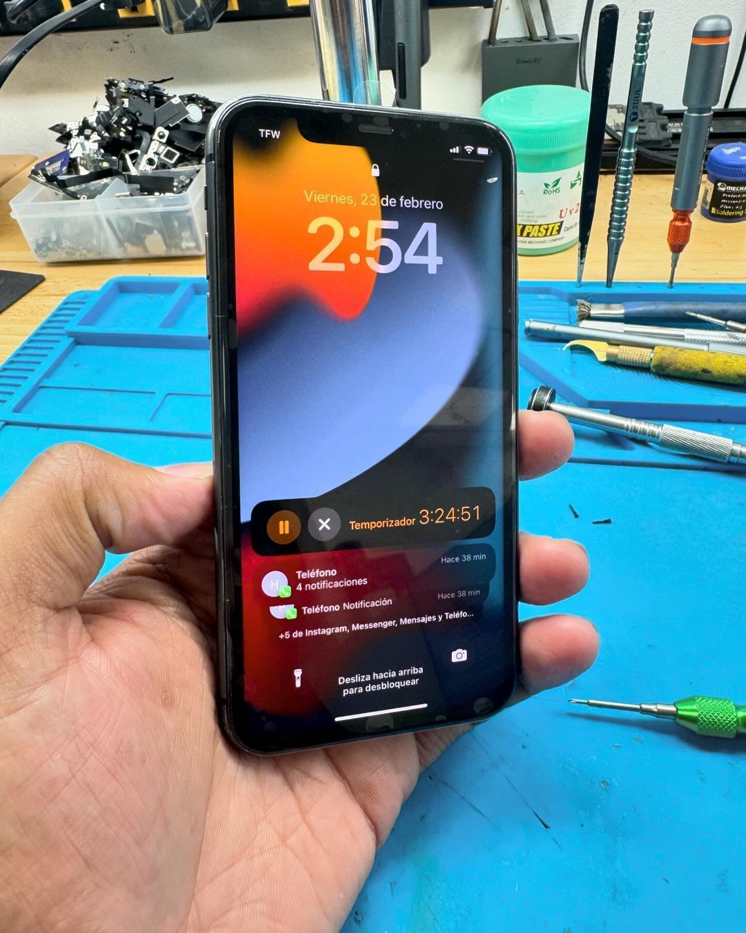 A person is holding a cell phone with the time of 2:54 on the screen