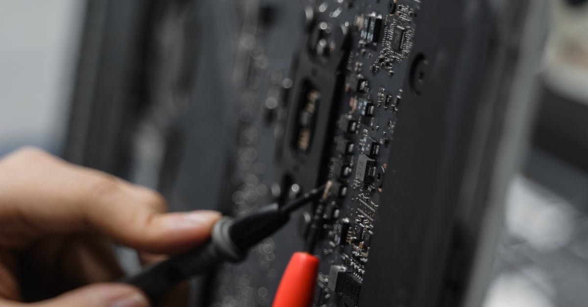 A person is holding a pair of tweezers over a motherboard.