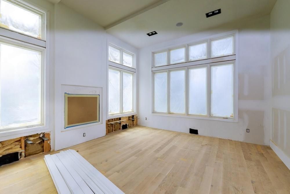 A large empty room with hardwood floors and lots of windows.