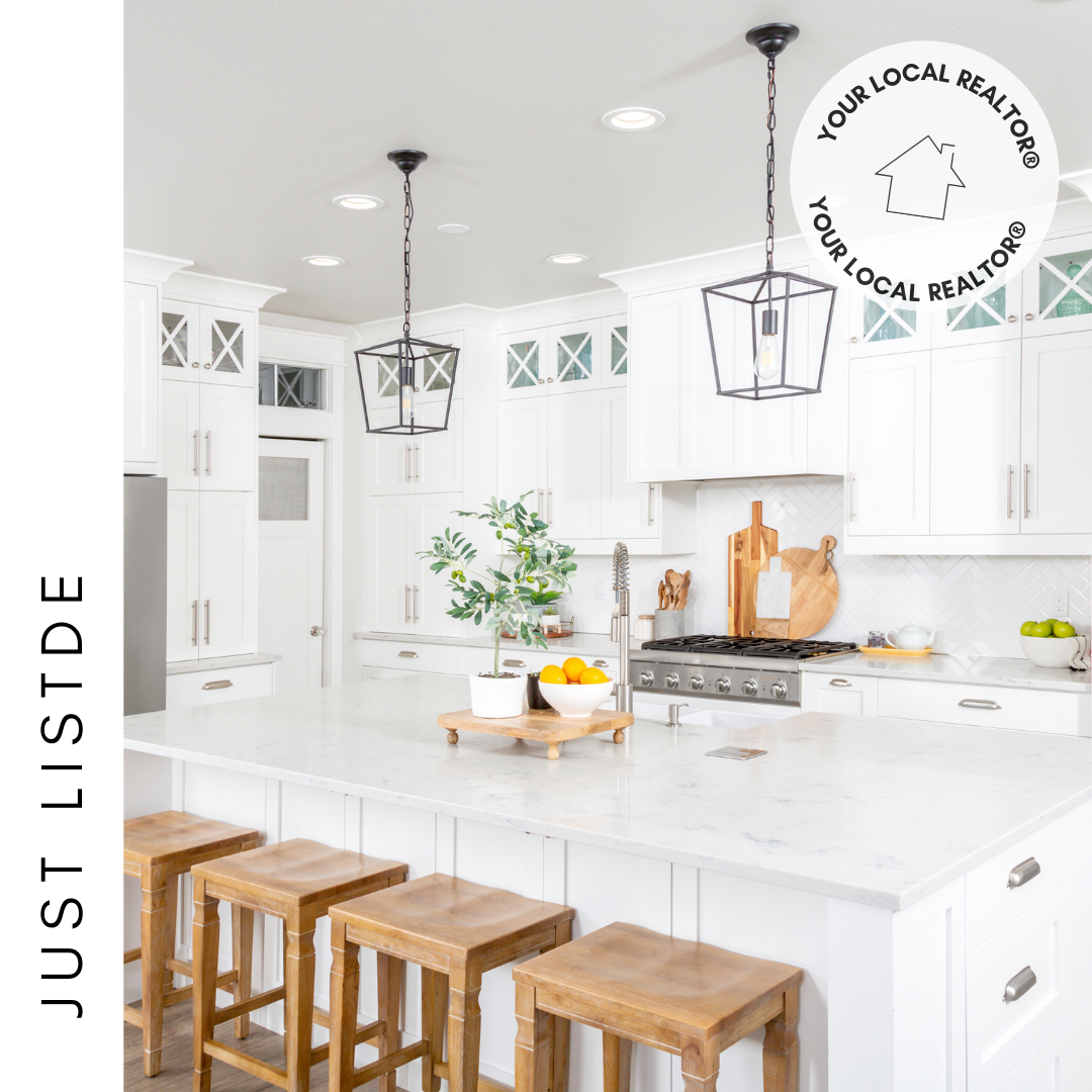 A kitchen with white cabinets and wooden stools.
