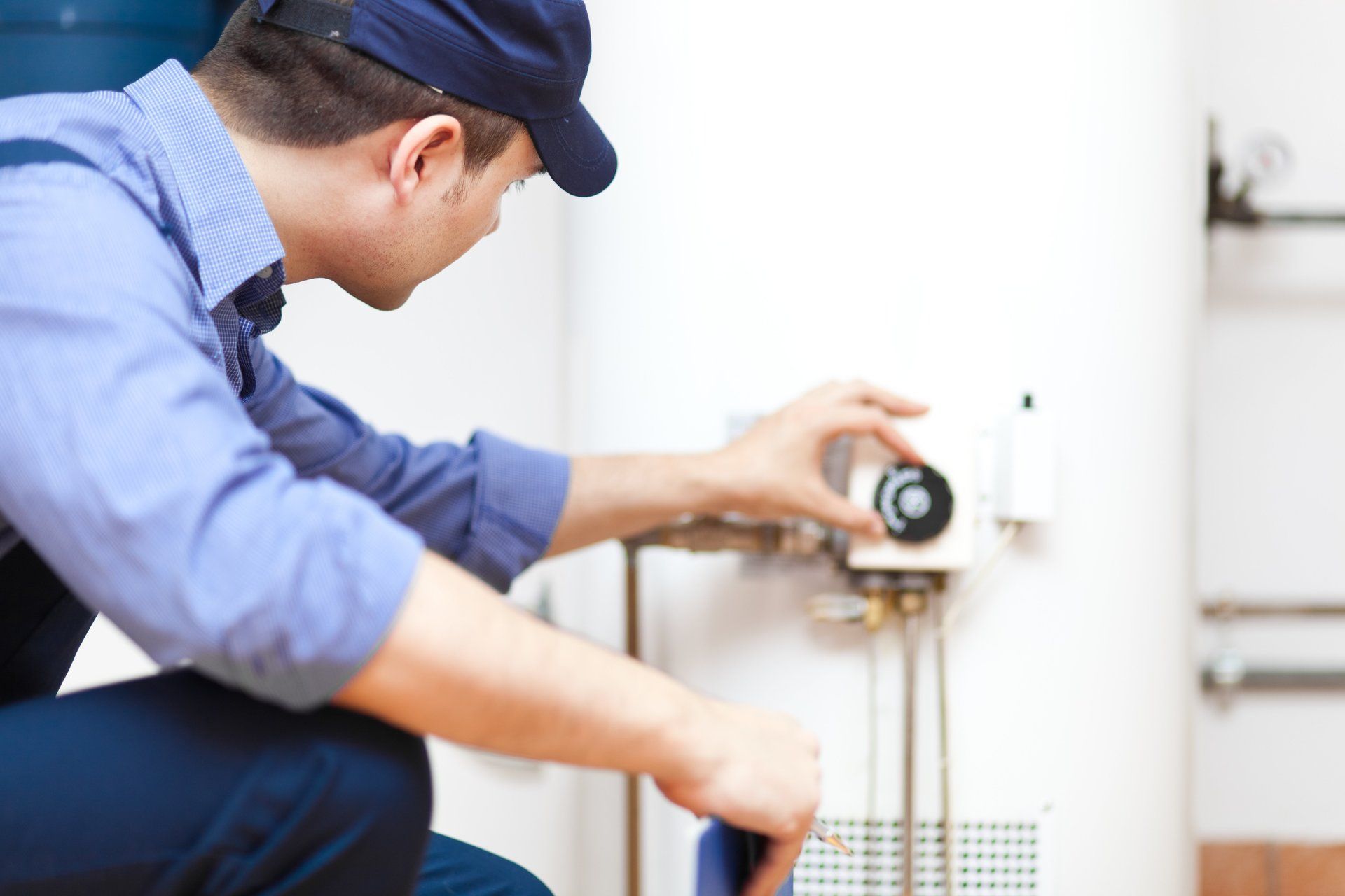 hvac service technician adjusting hot water heater