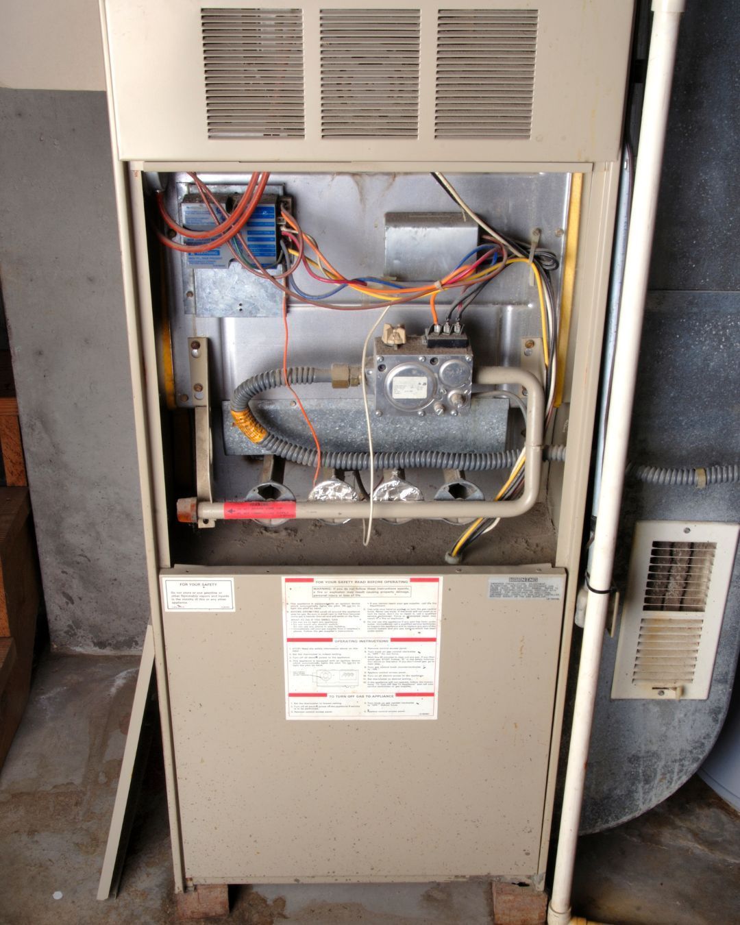 hvac service technician adjusting hot water heater