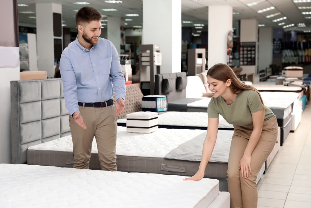 A Client Choosing a Mattress While Being Assisted by the a Store Manager