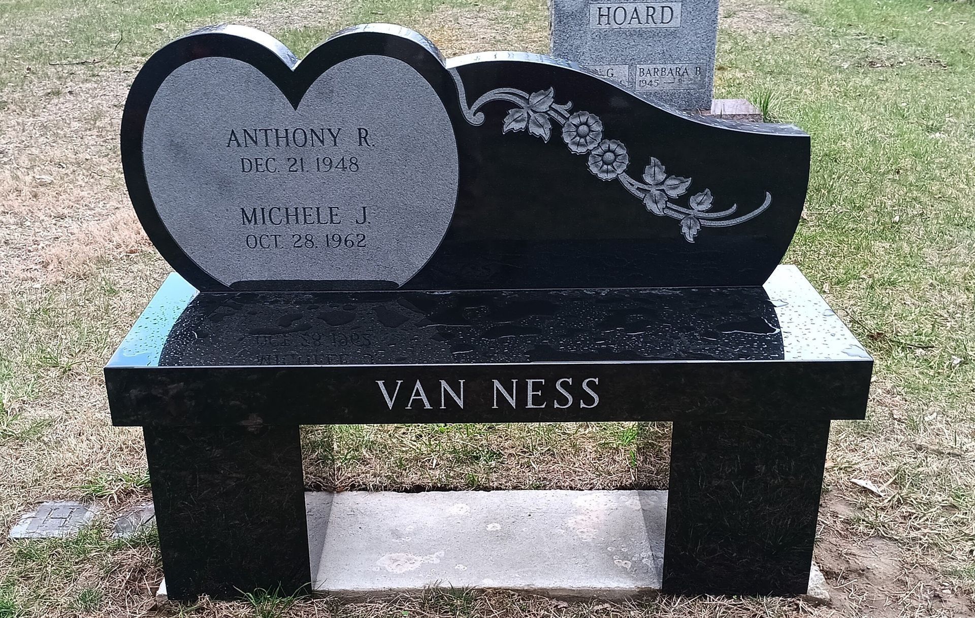 Black granite memorial bench with heart and floral details, engraved 