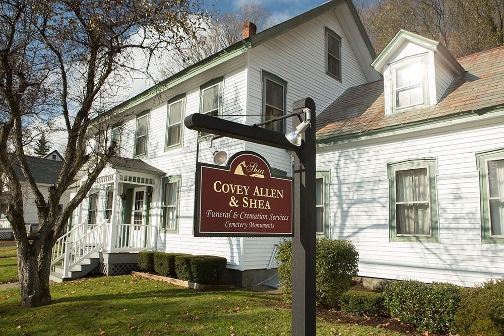 Sign for Law Firm: Cozy Allen & Smith, in front of a white building with green trim.