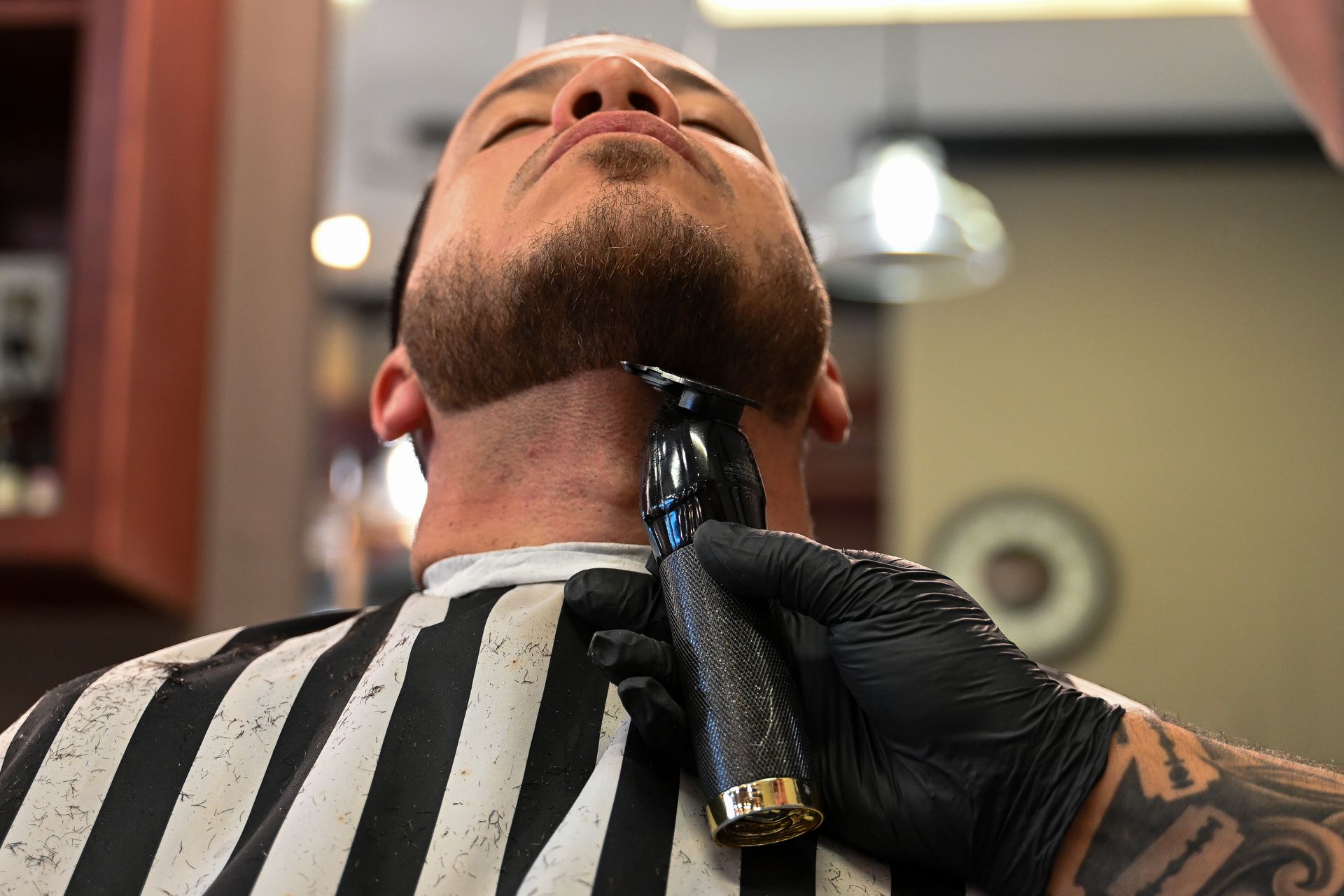 A man is getting his beard trimmed at a barber shop