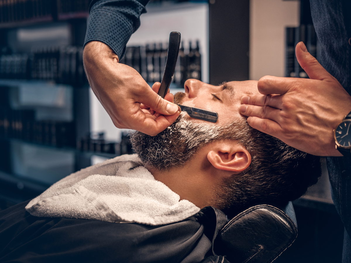 A person getting their face shaved at a barber shop