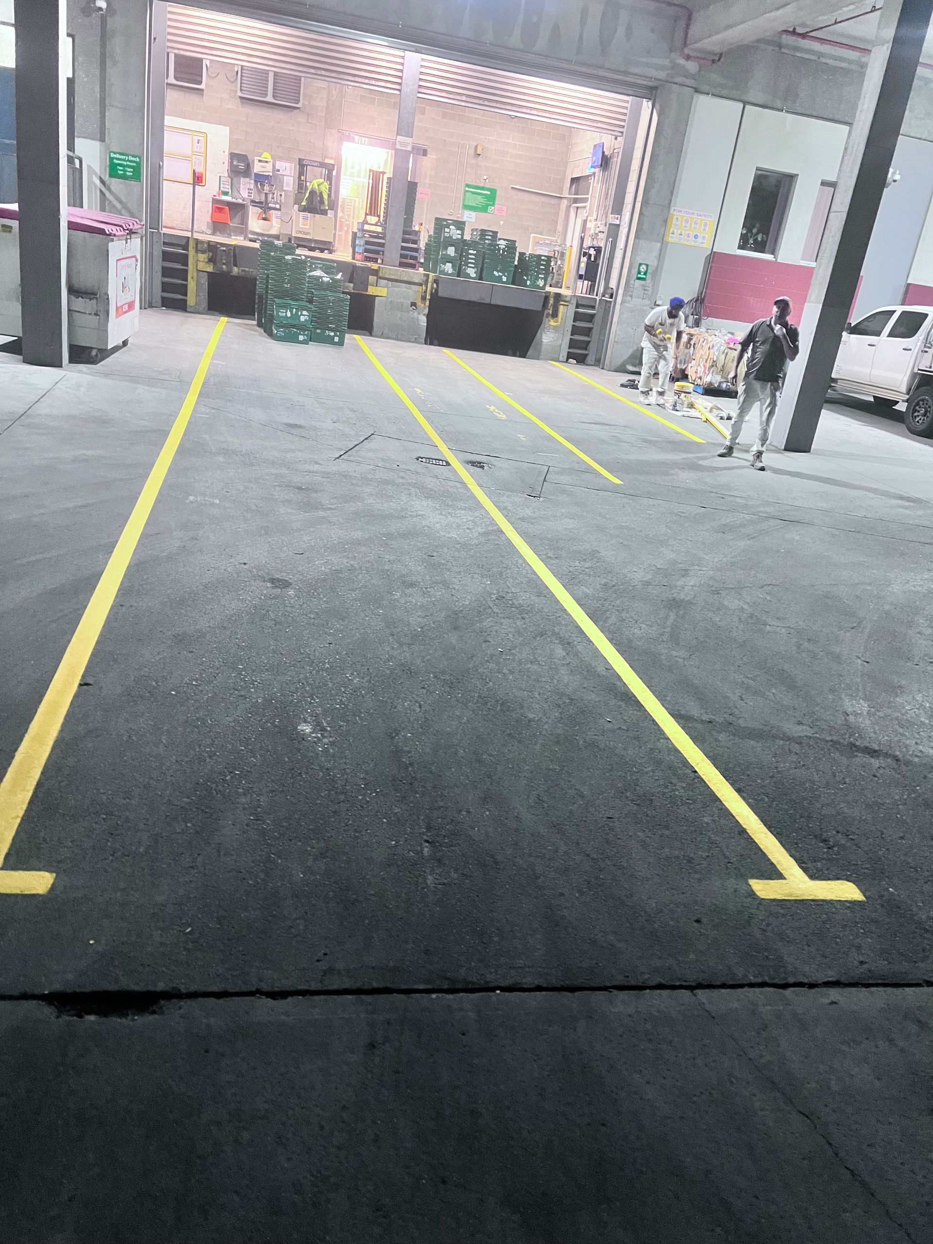 A man is standing in a parking lot next to a yellow line — Hobart, TAS — Campbell Painters Pty Ltd