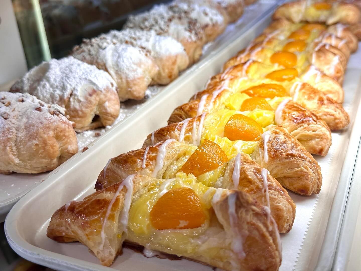 There are many different types of pastries on the trays.