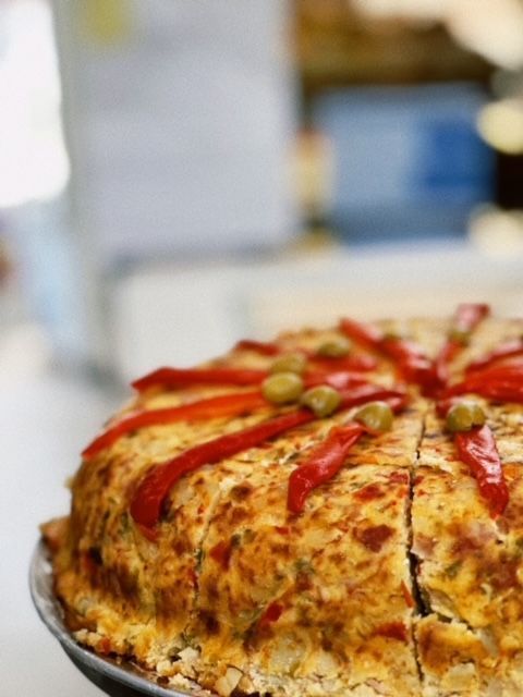 A close up of a pizza with peppers and olives on top