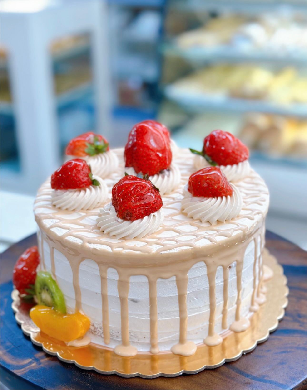A cake with strawberries and whipped cream on top of it.